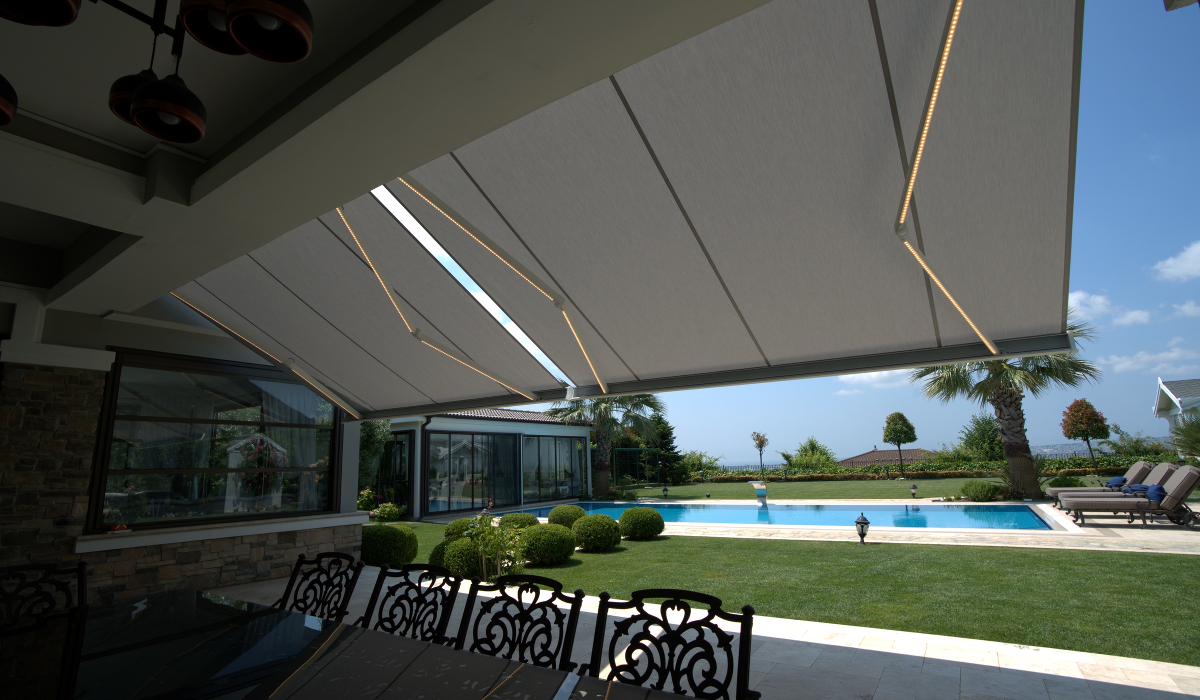 Large folding arm awning shading a wide terrace