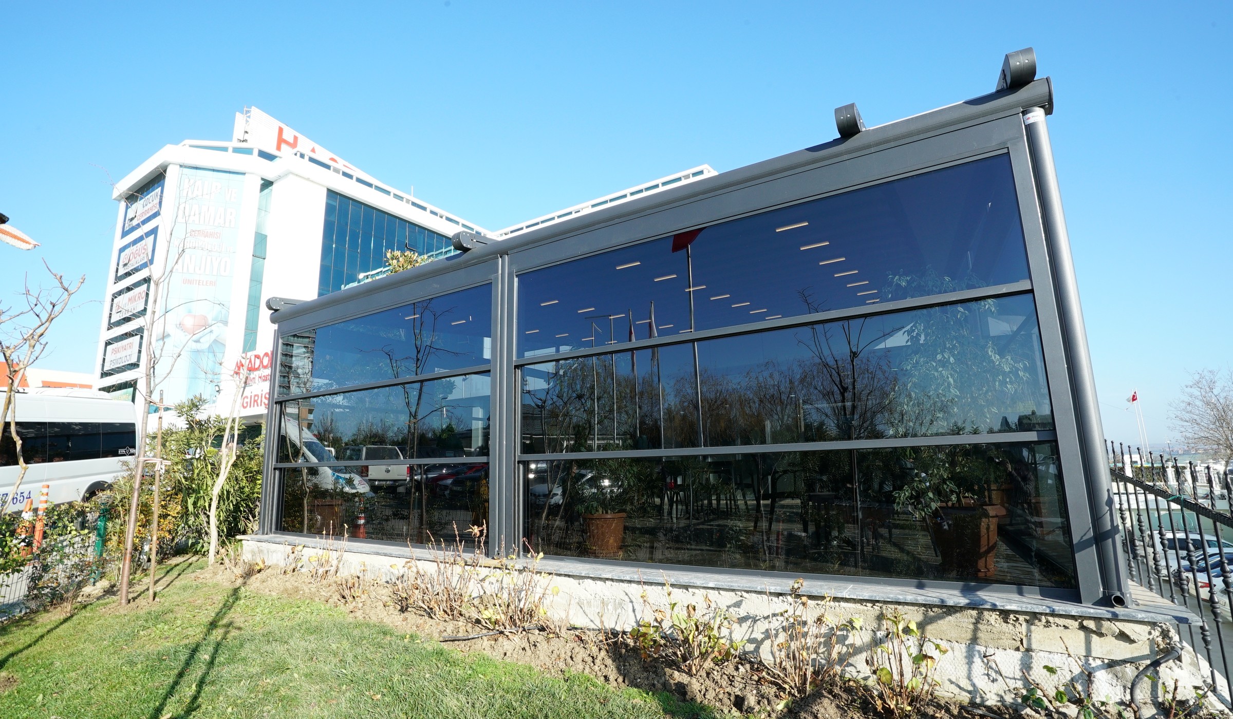Glass enclosed terrace with a retractable fabric roof above