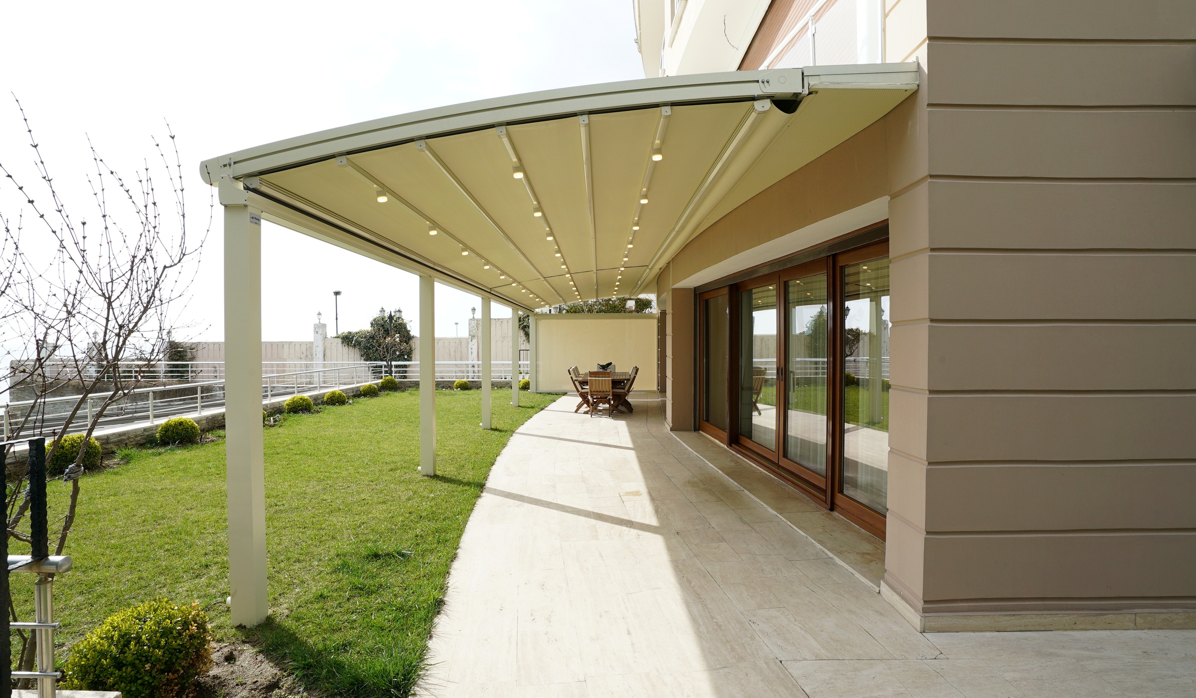 Villa terrace with a white fabric roof pergola along the facade