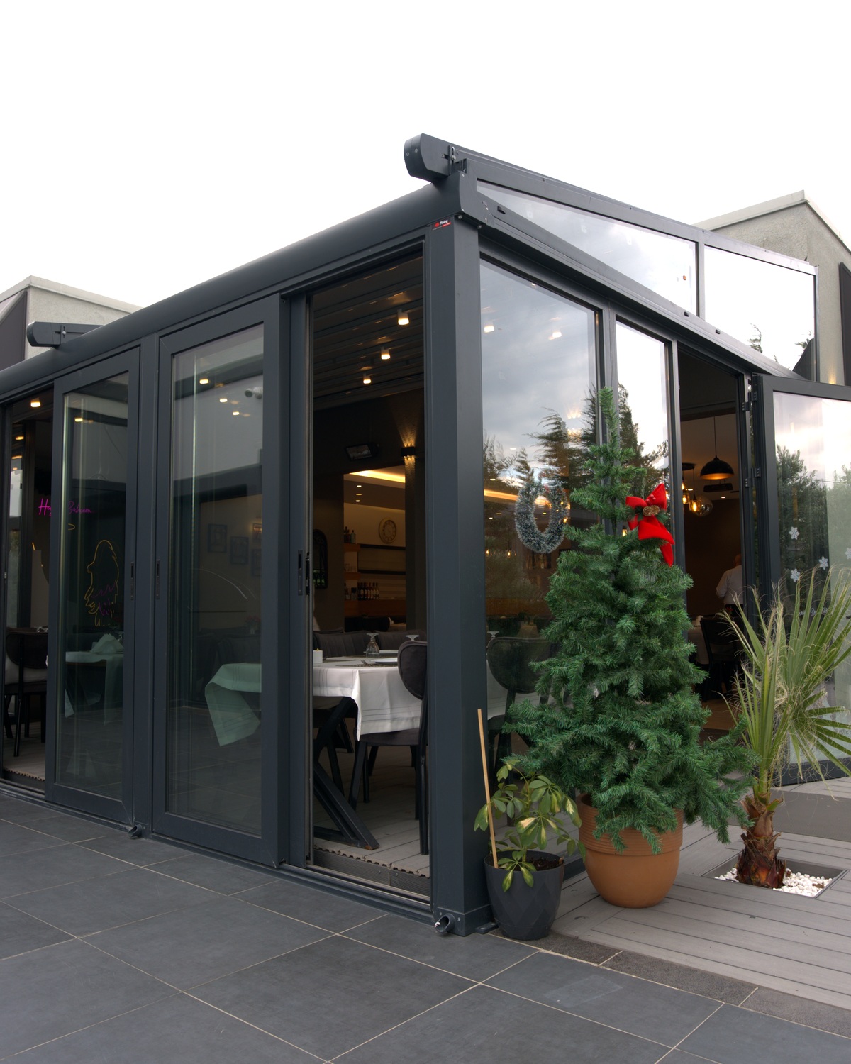 Rising glass enclosure system closing a terrace